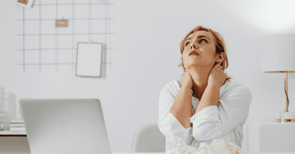 Mujer en oficina con signos de estrés laboral y agotamiento emocional